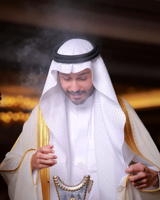 مضيف بثوب وبشت أبيض يقدّم المبخرة لضيوفه